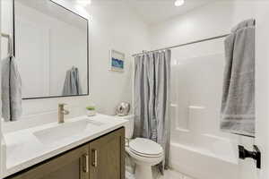 Full bathroom featuring shower / bath combination with curtain, vanity, and toilet