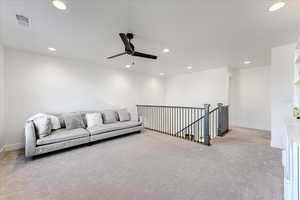 Carpeted living room with ceiling fan