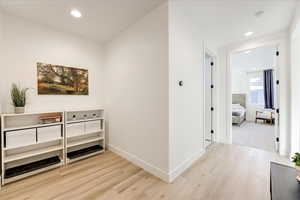 Hallway with light hardwood / wood-style flooring