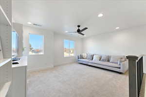 Carpeted living room featuring ceiling fan