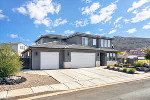 View of front of home with a mountain view and a garage