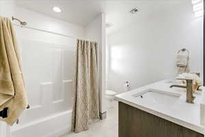 Full bathroom featuring toilet, vanity, tile patterned floors, and shower / tub combo with curtain