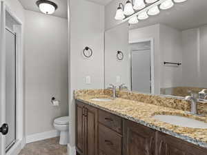 Bathroom with tile patterned floors, vanity, an enclosed shower, and toilet