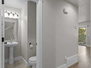 Bathroom with sink, wood-type flooring, and toilet