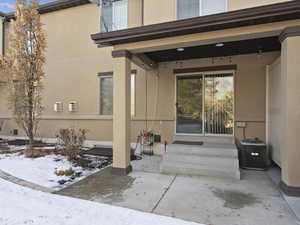 Snow covered property entrance featuring central air condition unit