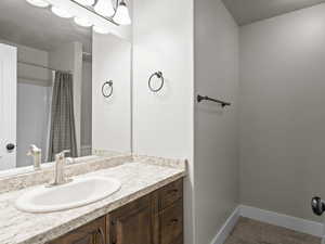 Bathroom with tile patterned floors, vanity, and a shower with shower curtain