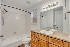 Full bathroom with toilet, vanity, bathtub / shower combination, and hardwood / wood-style flooring