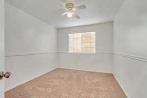 Empty room with light carpet and ceiling fan