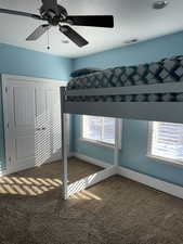 Unfurnished bedroom with carpet flooring, multiple windows, and ceiling fan