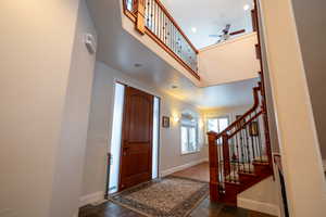 Entrance foyer featuring a high ceiling and ceiling fan