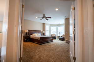 Primary bedroom with carpet flooring and ceiling fan