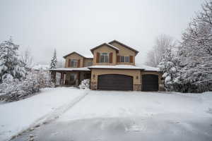 View of property featuring covered porch and a garage