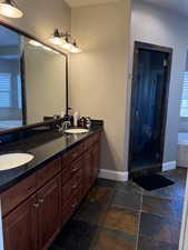 Primary Bathroom with plenty of natural light, separate shower and tub, and vanity