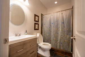 Main Floor Bathroom with a shower with curtain, tile patterned flooring, vanity, and toilet