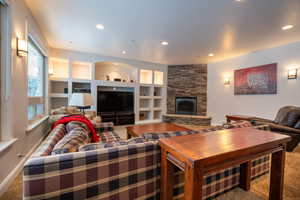 Living room featuring built in shelves, a fireplace, and carpet