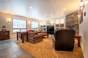 Living room with a stone fireplace and built in features