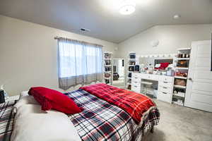 Carpeted bedroom featuring vaulted ceiling