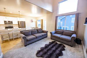 Living room with plenty of natural light, an inviting chandelier, and light hardwood / wood-style flooring