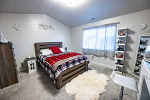 Carpeted bedroom with vaulted ceiling