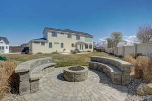 Back of house with a fire pit, a patio area, and a lawn