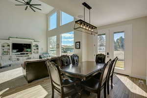 Dining area with french doors, light hardwood / wood-style flooring, a wealth of natural light, and ceiling fan