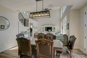 Dining area with a towering ceiling and light hardwood / wood-style floors