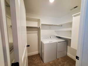 Laundry area featuring dark carpet and separate washer and dryer