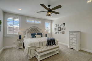 Carpeted bedroom featuring ceiling fan