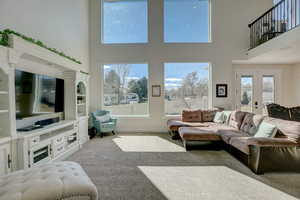 Living room featuring a towering ceiling and light colored carpet