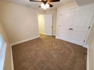 Unfurnished bedroom featuring carpet flooring, a closet, and ceiling fan