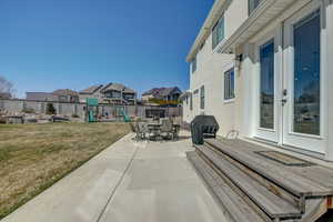 View of patio featuring area for grilling and a playground