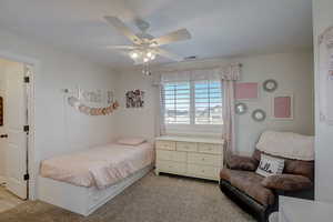 Carpeted bedroom featuring ceiling fan