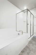 Bathroom featuring tile patterned floors and separate shower and tub