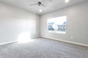 Empty room with carpet flooring and ceiling fan