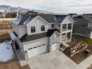 View of front of property featuring a mountain view, a balcony, and a garage