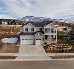 View of front of property with a mountain view, a garage, and a balcony