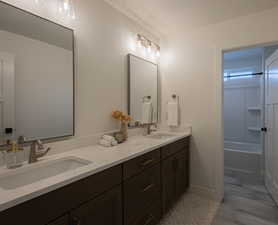 Bathroom featuring a textured ceiling, vanity, bathing tub / shower combination, and hardwood / wood-style floors