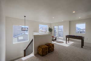 Recreation room featuring carpet flooring, a chandelier, and a textured ceiling