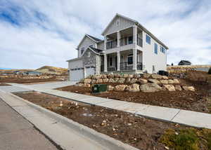 View of front of property featuring covered porch, central AC unit, a garage, and a balcony