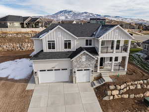 View of front of house featuring a mountain view, a balcony, and a garage