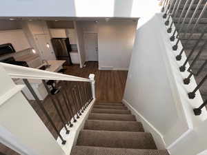 Staircase featuring sink and hardwood / wood-style flooring