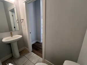 Bathroom featuring sink, toilet, and tile patterned flooring