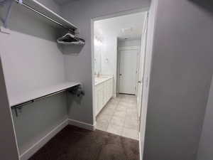 Walk in closet with light tile patterned floors and sink