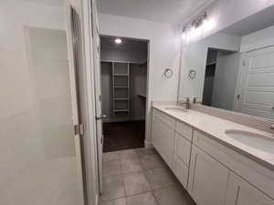 Bathroom featuring vanity, tile patterned flooring, and a textured ceiling