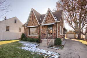 View of front of property featuring a front lawn, an outdoor structure, and a garage