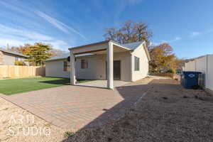 Back of house with a lawn and a patio