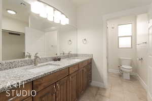 Bathroom featuring toilet, vanity, and tile patterned floors