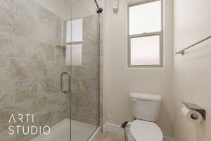 Bathroom with a shower with shower door and toilet