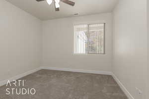 Carpeted empty room featuring ceiling fan