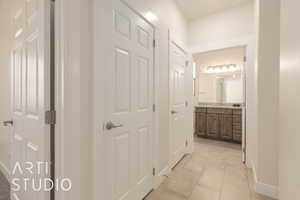 Corridor featuring light tile patterned floors and sink